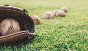 A baseball glove and baseballs shown on the field of a LEED certified MLB stadium implementing Marsden's innovative waste management and recycling plan