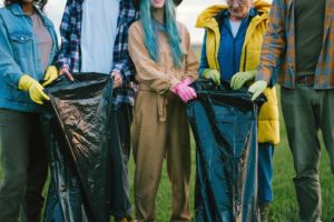 A group of community members cleaning up trash outdoors as a group