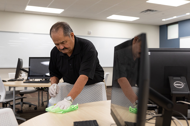 Janitorial and disinfection associate cleaning a hot desking commercial office